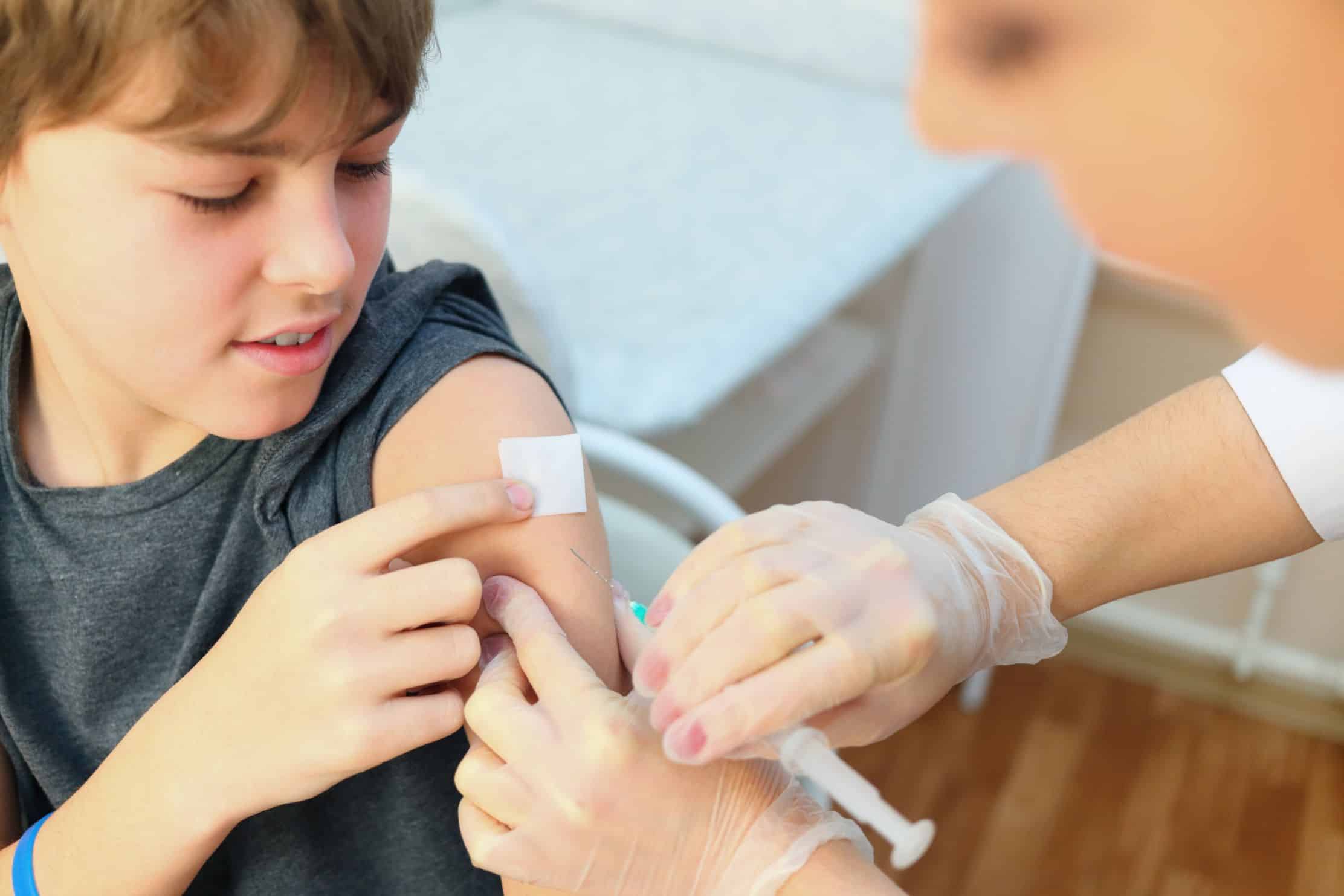 Doctor giving boy an immunisation shot